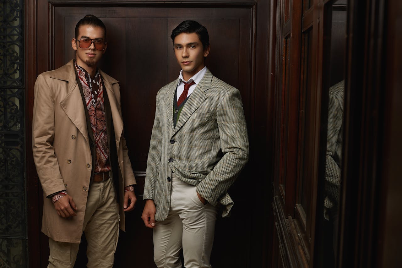 brand-02 Two men in fashionable suits posing indoors, showcasing elegance and style.